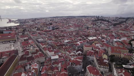Scenic-drone-orbit-over-red-rooftops-in-Lisbon-skyline,-old-town-Portugal