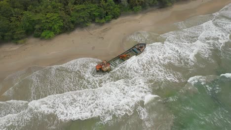 Manzanillo-shipwreck-stuck-on-sandy-beach-with-waves-on-Costa-Rica-shore