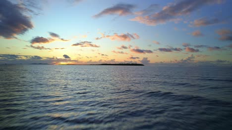 Cielo-Lleno-De-Nubes-Doradas-Al-Atardecer-Sobre-Islas-Tropicales-Y-Olas,-Fiji