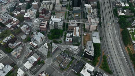 Drone-shot-tilting-up-to-reveal-Seattle's-dense-sector-of-skyscrapers-on-a-cloudy-day