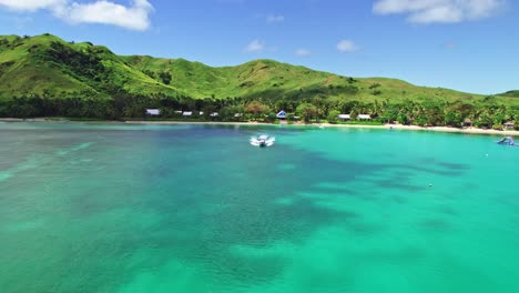 Boat-departing-tropical-island-beach-lodge,-Nacula,-Yasawa,-Fiji