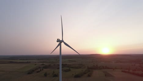 Aerial-view-of-windmill-spinning-at-sunset-in-European-country