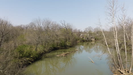 Aerial-shot-of-fallen-branches-in-the-West-Fork-White-River-with-a-pump-station-behind