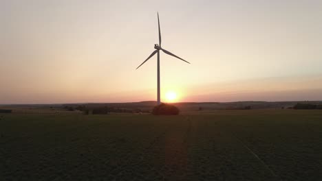 Scenic-aerial-view-of-single-wind-turbine-rotating-at-sunset-in-countryside-of-southern-Spain