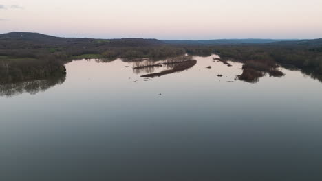 Rotierende-Luftaufnahme-Des-Sonnenuntergangs,-Der-Sich-Auf-Der-Oberfläche-Des-Sequoyah-Sees-Spiegelt