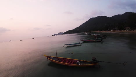 Cinematic-acrobatic-FPV-shot-above-long-fishing-boats-anchored-in-Koh-Tao
