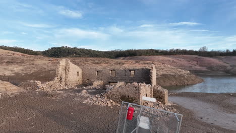 Muelle-Inaccesible-E-Inutilizable-Y-Ruina-Del-Edificio-En-Las-Costas-Secas-Del-Pantano-De-Sau-En-Cataluña,-España