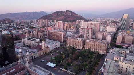Aerial-dolly-towards-the-Plaza-de-Armas-with-the-San-Cristobal-Hill-with-the-Costanera-tower