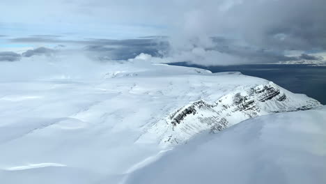 Aerial-view-of-untouched-nature-in-the-arctic-circle-Northern-Norway-Finnmark,-snow-covered-cliffs-and-mountains