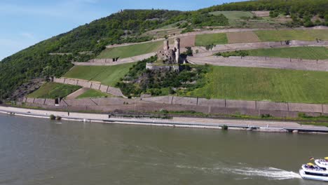 Sightseeing-Excursion-boat-cruising-past-Ehrenfels-Castle-up-the-River-in-upper-middle-Rhine-valley,-Germany