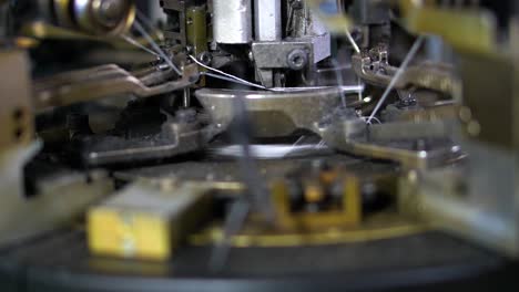 The-process-of-manufacturing-of-socks-on-a-loom---Close-up-shot-of-Spools-with-white-thread-at-rewinding-machine-video