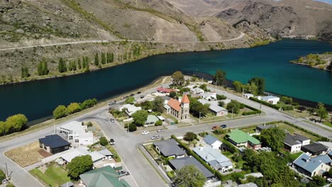 Aerial-view-of-scenic-riverfront-of-Cromwell-town-in-Central-Otago,-New-Zealand-on-sunny-summer-day,-drone-shot