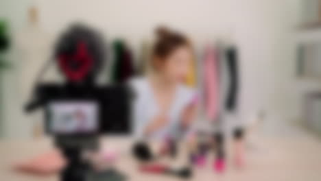 Blurred-shot-of-female-cosmetics-beauty-influencer-creating-makeup-video-content