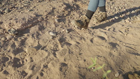 Women-Hiker-Drops-Sleeping-Bag-in-Dirt-and-Sand-on-Desert-Hike