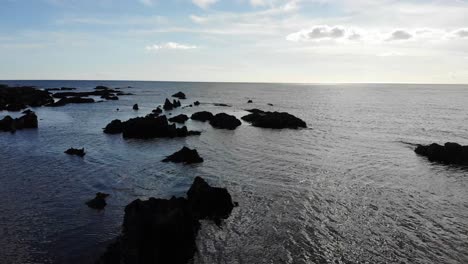 Aerial-drone-shot-captures-reflective-water-and-coastline-rocks,-Thurlestone,-South-Devon-England-UK