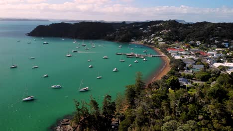 Ferry-leaving-Russel-port-to-Paihia,-bay-with-anchored-yachts