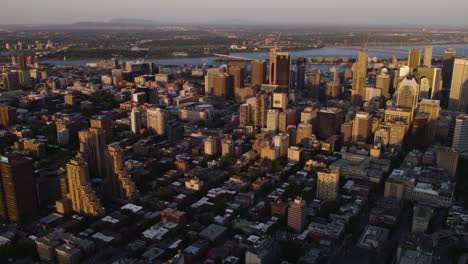 Aerial-view-overlooking-the-cityscape-of-downtown-Montreal,-golden-hour-in-Canada