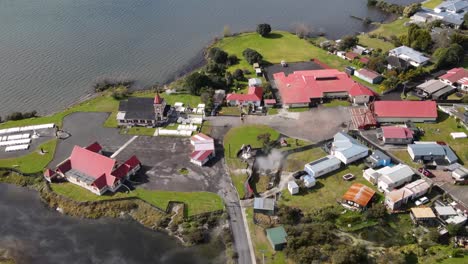 Amazing-view-of-Ohinemutu-historic-Maori-living-village,-aerial-reveal-of-Lake-Rotorua-lakeside,-New-Zealand