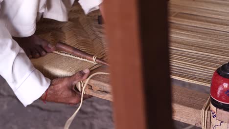 Nahaufnahme-Eines-Arbeiters-Beim-Weben-Zur-Herstellung-Von-Charpai,-Einem-Traditionellen-Gewebten-Bett-In-Sindh,-Pakistan