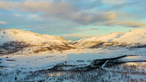Aerial-in-low-light-over-the-snow-covered-valley-and-mountains-in-Hemsedal,-Norway