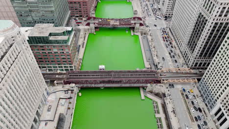 Aerial-view-following-a-tourist-ferry-on-the-Chicago-river-on-St