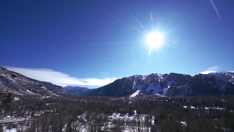 Downtown-scenic-view-of-Aspen-Mountain-mid-winter-early-morning-sun-flare-panning-to-the-right