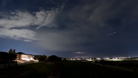 Cloudscape-and-stars-crossing-the-sky-above-a-suburban-community-at-nighttime---time-lapse