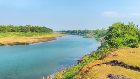 Establisher-panning-shot-of-Surma-river-in-Sylhet,-Bangladesh,-sunny-day