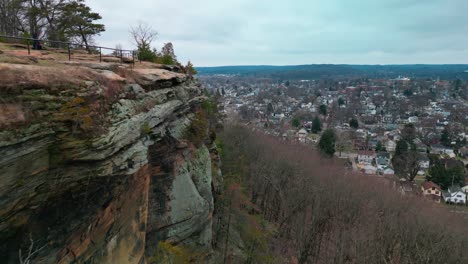 Aerial-view-along-tall-cliff,-Mount-Pleasant,-Lancaster,-Ohio-with-neighborhoods-in-background