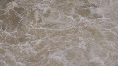Handaufnahme-Des-Turbulenten-Wasserflusses-Vom-Hinze-Staudamm-Bei-Starkem-Regen-Und-Wasserströmen-Während-La-Niña,-Hinterland-Der-Goldküste,-Queensland,-Australien