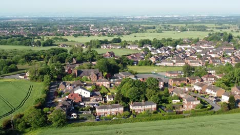 Descending-drone-shots-of-the-idyllic-cronton-village-farmland-in-united-kingdom-england-overlooking-the-beautiful-countryside-with-residential-houses