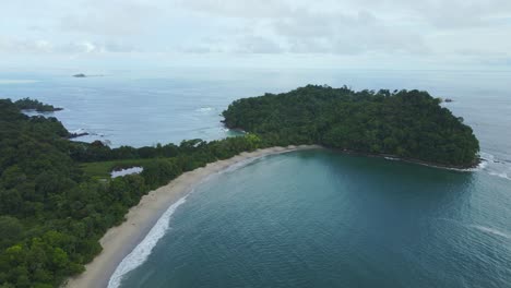 Aerial-drone-panning-shot-of-Manuel-Antonio-beach-on-a-partly-cloudy-day
