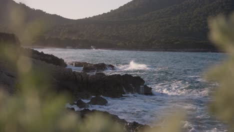 Beautiful-Waves-crashing-onto-rocky-shoreline-on-Spanish-Island-at-golden-hour-sunset