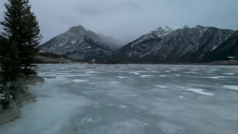 Antena-De-La-Costa-Del-Lago-Congelado-Frío-Con-Montañas,-Alberta,-Canadá