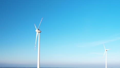 Windkraftanlage-Windturbinen-Drehen-Sich-Bei-Sonnenuntergang-über-Dem-Klaren-Blauen-Himmel