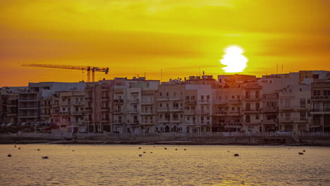 A-spectacular-sunset-provides-an-unrealistic-picture-of-the-harbor-and-houses-at-Gira,-in-Malta's-Central-Region,-between-Msida-and-Sliema