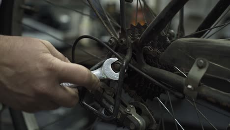 Un-Mecánico-De-Bicicletas-Apretando-La-Tuerca-De-La-Rueda-Trasera