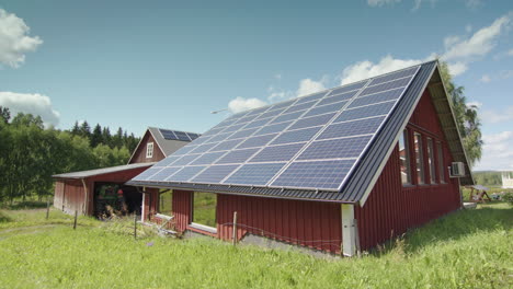 Barn-roof-on-farm-covered-in-solar-panels,-slow-aerial-trucking-shot