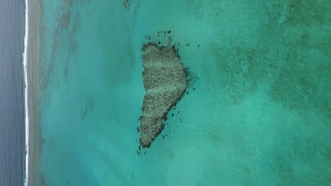 Paralaje-Aéreo-Vertical-Sobre-El-Corazón-De-Poé-Frente-A-La-Playa-De-Poé,-Nueva-Caledonia