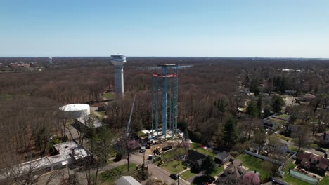 An-aerial-view-of-a-decommissioned-water-tower-being-dismantled-on-a-sunny-day-on-Long-Island,-New-York