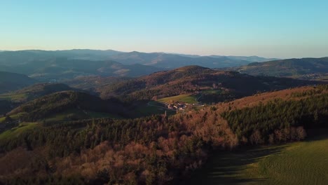 Vista-De-Drones-De-La-Campiña-Francesa-Con-Bosques,-Colinas-Y-Dominio-En-Ardèche-Bajo-La-Puesta-De-Sol
