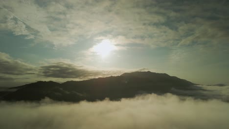 Drone-Flight-Backwards-From-Bright-Sun-Over-Cloud-At-Sunset,-4K