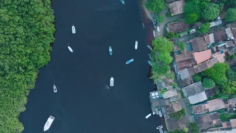 Aerial-Top-Down-Drone-View-of-rural-beach-town-Caraiva-Bahia-Brazil-flying-over-the-river-with-boats