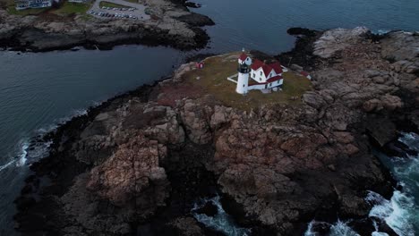 Tilting-rotation-above-a-lighthouse-on-a-rocky-Island-off-the-coast-of-southern-Maine-with-tides-crashing-on-the-rocks