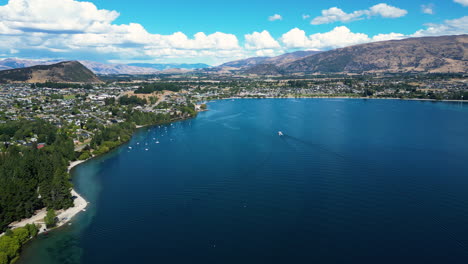 Wanaka-cityscape-on-lake-coastline-in-New-Zealand,-aerial-drone-view