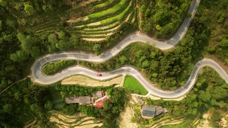Windy-road-with-traffic-weaving-through-lush-layered-hillside-rice-paddy-plantations-in-North-Vietnam-countryside