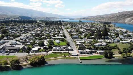 Cromwell,-New-Zealand,-Aerial-View-of-Sunny-Cityscape-by-Turquoise-Clutha-River-on-Summer-Day,-Picturesque-Town-in-Central-Otago