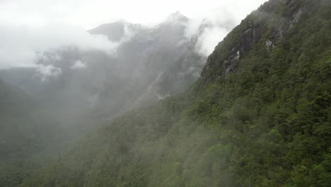 Drone-fly-in-fog,-Fiordland-National-Park,-amazing-high-mountains-landscape-of-New-Zealand