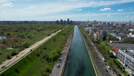 Captivating-Bird's-Eye-View-of-Dambovita-River,-Vacaresti-Delta,-and-Verdant-Surroundings-Against-a-Serene-Blue-Sky,-Summer,-Spring-Bucharest,-Romania