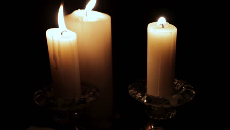 Holy-Bible-Lit-by-Candle-Light-in-a-Hidden,-Dark-Place-:-Slow-Pan-Down